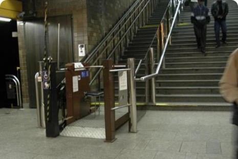 Dolní nástup plošiny na nástupišti Na snímku je plošina v dolní stanici, připravená na nástup cestujícího a následně k jeho přepravě do vestibulu stanice.