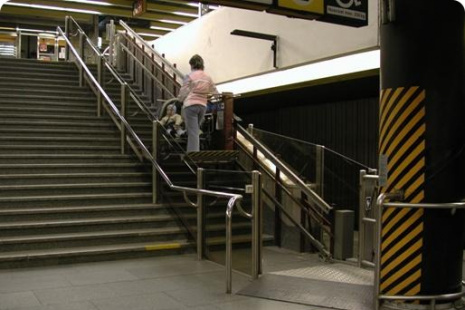 Dolní nástup druhé plošiny v úrovni nástupiště. Na snímku je plošina, přepravující cestující z nástupiště metra do spojovací chodby.